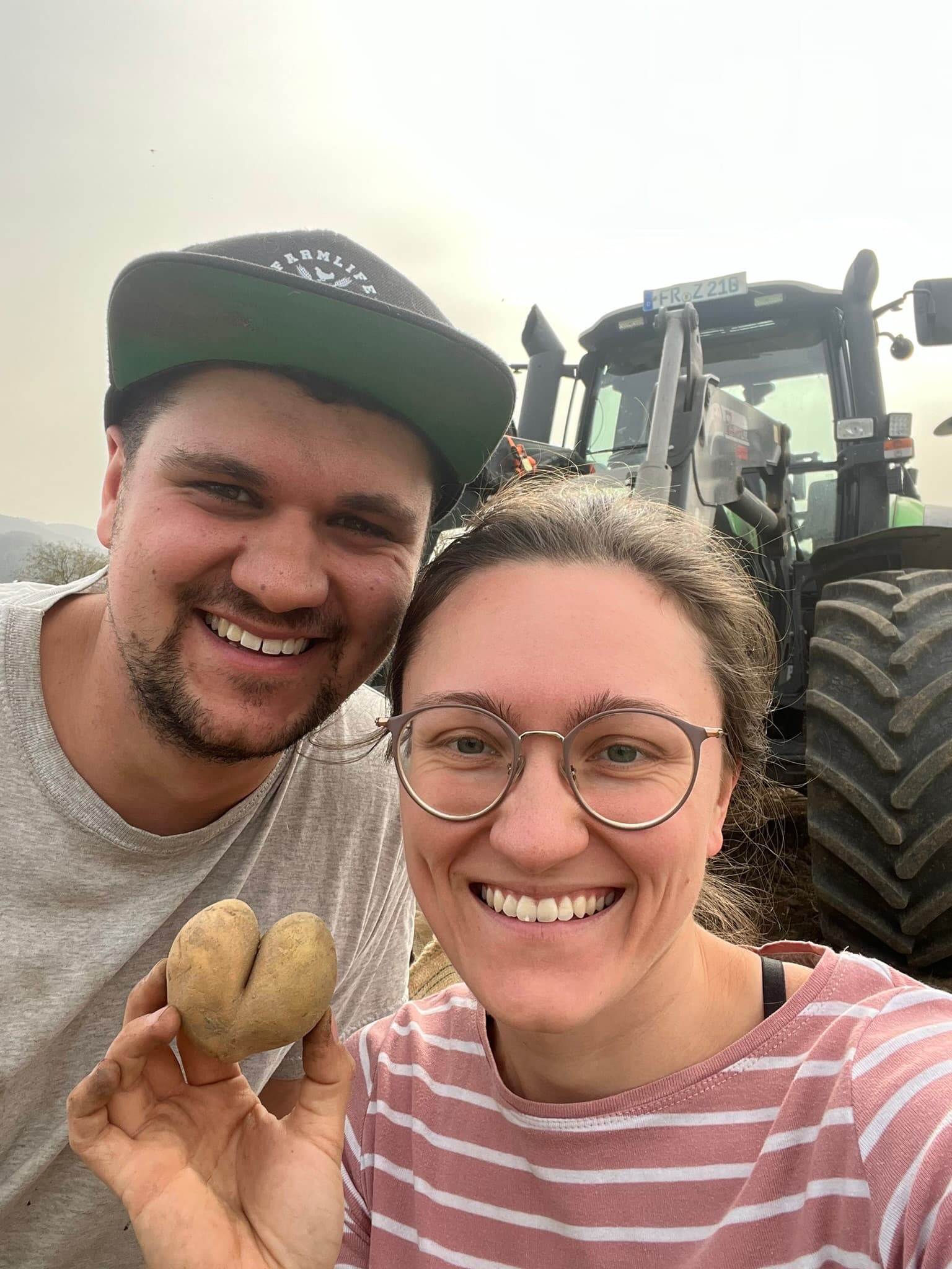 Oli und Melissa mit einer Herz-Kartoffel vor dem Traktor